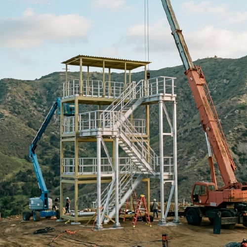 Modular tower structure being installed on rugged terrain, illustrating how CoverSix facilities are configured for unique site environments.
