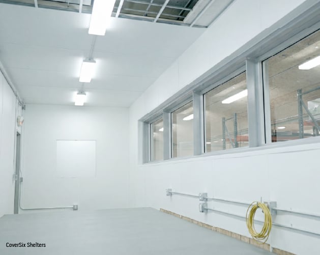 Interior view of a hardened modular control room for a shooting range, with protected observation windows.