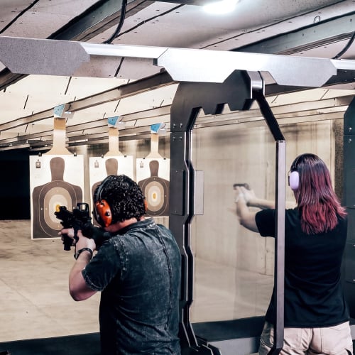 Personnel conducting firearms training at an indoor live-fire range.